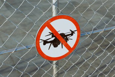 An image depicts a 'No Drone' sign on a fence surrounding an airport, serving as a warning for unauthorized aerial vehicles. The sign is clearly visible and readable. Importance of safety and security clipart