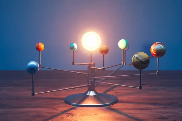 Toy Solar system model standing on a desk in a room. All eight planets on the spinning arms rotating around the bright light bulb imitating the Sun. Perfect for educational purposes.