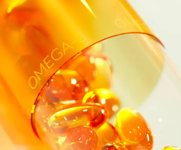 Big yellow translucent gel capsule filled with smaller omega 3, vitamin D, fish oil or cod liver oil pills. Close up of vitamin supplement. Healthy lifestyle, diet, nutrition, medication concept