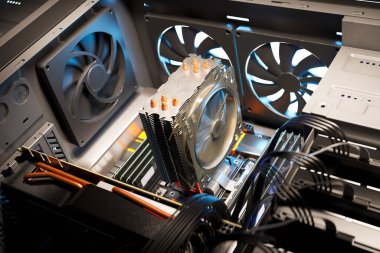 Bir bilgisayar çantasının içindeki anakart görüntüsünü yakınlaştır. Radyatörlerde çalışan, ana karta bağlı donanım bilgisayar parçalarını soğutan. Dönen vantilatörü yakınlaştır. GPU, CPU, RAM, SSD, Power Supply