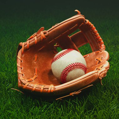 İyi kullanılmış, hakiki deri bir beyzbol eldiveni zümrüt yeşili bir çimenlikte el değmemiş bir beyzbol topunu beşikte tutarak oyun, rekabet ve nostalji hissi uyandırır..