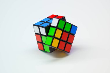 Bu resim, küpün parlak renkli karelerini ve ikonik tasarımı vurgulayarak, beyaz bir arkaplan karşısında karmaşık bir şekilde çözülmüş Rubik Küpünü sergiliyor..