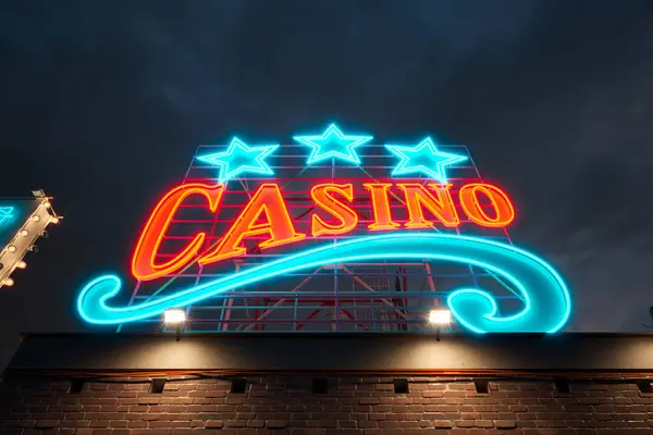 Old fashioned casino sign on the top of the roof glowing at night. Bright neon blue and orange banner. Can represent Las Vegas, addiction, gambling, poker, entertainment, gaming, fun, leisure