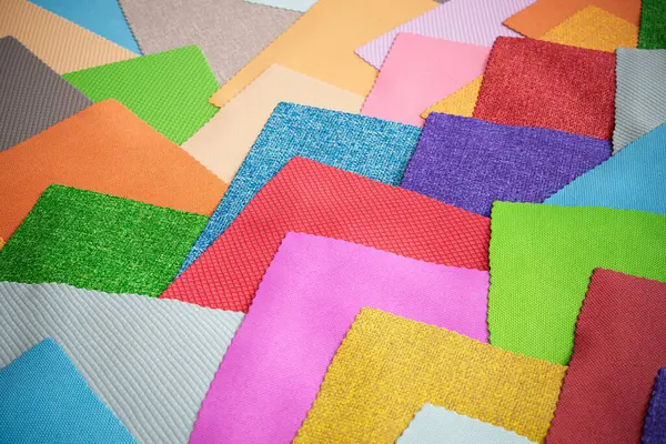 A set of colorful fabric samples. Square pieces of material in various colors. Concept of textile decoration trends for furniture or interiors. DIY enthusiast. Textile designer. Collection of cloths.