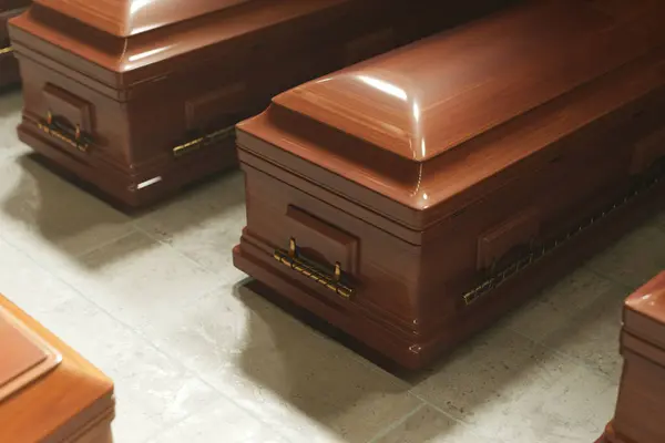 A set of highly-polished, elegant mahogany coffins with shiny brass handles precisely aligned on a reflective grey tiled floor within a tranquil funeral home setting.