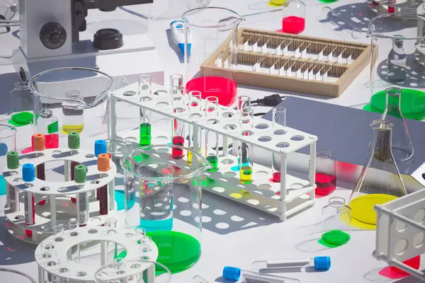 An intricate display of laboratory instruments against a sterile backdrop, with vivid chemical reactions occurring in beakers and test tubesdepicting cutting-edge scientific investigation