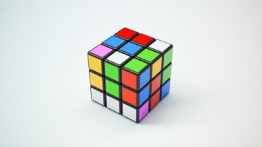 Tamamlamanın farklı aşamalarında 3D Rubik küpü, beyaz arkaplanda canlı renkler sergiliyor.