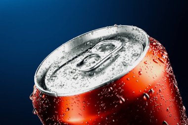 A striking close-up image showcasing a vibrant red soda can, beaded with refreshing condensation droplets, highlighting a concept of cool refreshment on a stark blue backdrop. clipart