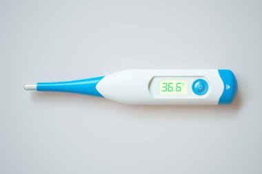 36.6C 'lik normal vücut sıcaklığını gösteren yüksek hassasiyetli dijital termometre, saf beyaz bir arkaplan karşısında zarif bir şekilde izole edilmiş, sağlık denetiminde doğruluğu simgeliyor.
