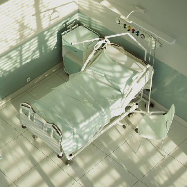 A spacious, sunlit hospital room with an unoccupied bed, showcasing state-of-the-art medical equipment, crisp linens, and a solitary chair, embodying a tranquil healing space. clipart