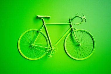 Kusursuz tasarlanmış, çarpıcı yeşil bir bisiklet, bu monokromatik düzende minimalist ama cesur bir estetiği temsil eden, mükemmel bir şekilde eşleştirilmiş yeşil bir arkaplana dayanır..