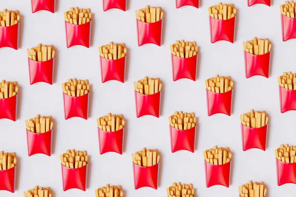 A neatly organized array of red French fry cartons creates a striking, repetitive pattern, evoking fast food themes; perfect for design and culinary graphics.