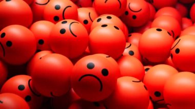Çok sayıda kırmızı balonu gösteren yakın plan bir resim. Üzüntü ve olumsuzluk duygularını taşıyan siyah üzgün gülümsemelerle damgalanmış..
