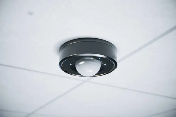 Detailed view of an advanced motion sensor mounted on the ceiling within a modern office setting, emphasizing its sleek and functional design for enhanced security.