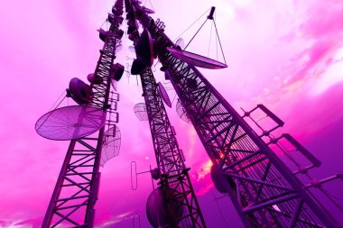 Uydu antenleri ve antenlerle süslenmiş, büyüleyici telekomünikasyon yapıları, hepsi mor bir günbatımının ruhani ışıltısında güneşleniyor..