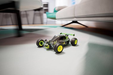 Dinamik bir sahne, iyi döşenmiş çağdaş oturma odasının parlak renkli, uzaktan kumandalı oyuncak arabasının cilalı zemininde hızla ilerlemesiyle ortaya çıkar..