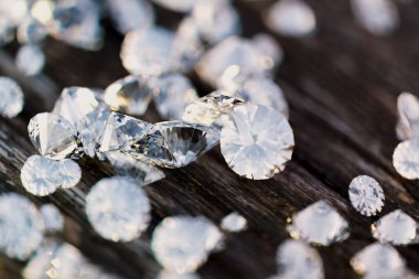 Bu resim çeşitli kesiklerle nefes kesici bir dizi elmas sergiliyor, kırsal ahşap bir yüzeye zarif bir şekilde dağılmış, dokularda çarpıcı bir kontrastı vurguluyor.