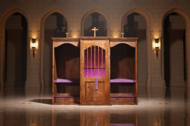 Bu resim iki geleneksel ahşap günah çıkarma kabinini çekiyor, haçlarla süslenmiş, bir kilise salonunun huzurlu atmosferinde, derin dini sembolizm ve ruhaniliğin somutlaştırılmış hali..