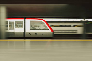 Hareket halinde yakalanan bu görüntüde şehir istasyonunda hızla ilerleyen modern bir metro treni, şehir hayatının ve toplu taşıma verimliliğinin özünü vurguluyor..