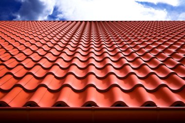 Büyüleyici bir manzara kırmızı terracotta çatı kiremitlerinin karmaşık desenlerini ve dokusunu gözler önüne seriyor, parlak, açık mavi gökyüzü ile güzelce zıt düşüyor. Mimari temalar için ideal.