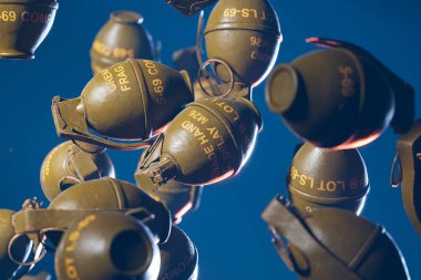 Savaş ve barış arasındaki hassas dengeyi sembolize eden, çarpıcı mavi gökyüzüne karşı yükselen klasik el bombalarının çarpıcı görüntüsü..