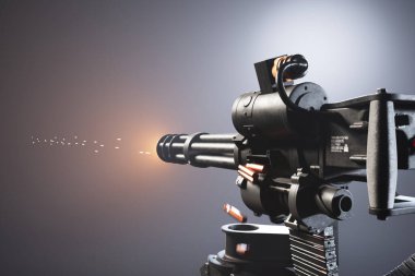 Fütürist bir mini silahın yüksek çözünürlüklü görüntüsü, parlayan mermi izleri ve fırlatılan mermilerle dinamik ateşleme sergiliyor. Gelişmiş savaş teknolojisi için ideal..