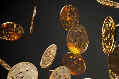 Bu resim, kripto para piyasasının değişken ve sürekli gelişen doğasını karanlık bir arka plana karşı gösteren altın Bitcoin paralarının dinamik bir çağlamasını yakalar..