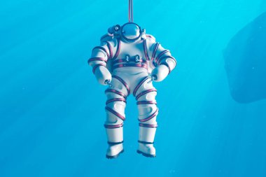 Titizlikle tasarlanmış bir su altı tesisinde, tam uzay teçhizatlı bir astronot, yükselen kabarcıklar arasında sıfır yerçekimi koşulları simülasyonu yaparak sıkı bir uzay yürüyüşü eğitiminden geçer..