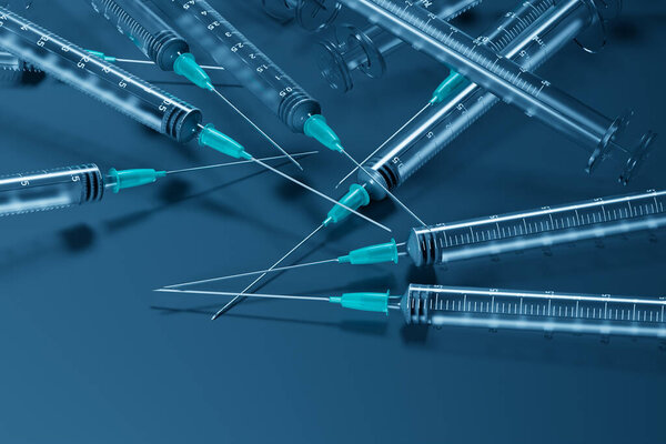 На этом изображении изображены различные медицинские шприцы, аккуратно разбросанные на синем фоне, символизирующие медицинскую подготовку и готовность к лечению..