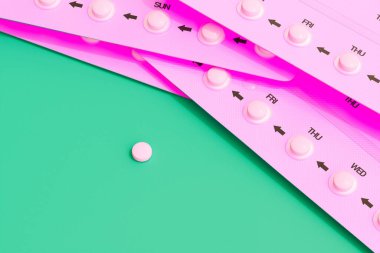 Bu görüntü ilaç yönetiminin özünü yansıtıyor, şeritler üzerinde pembe haplar ve çarpıcı yeşil bir arka plana karşı ayrık bir tablet, sağlık hizmetlerini vurguluyor..