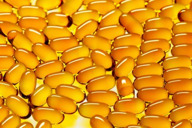 This high-resolution image captures golden fish oil capsules up close, highlighting their importance as a dietary supplement rich in Omega-3 for health and wellness. clipart