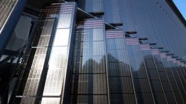 Entegre güneş panelleri içeren gösterişli mimari ön cephe. Yansıtıcı cam ve metal elementlerle gelişmiş tasarımı vurgulamak. Kentsel mimaride sürdürülebilir enerji.