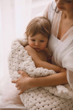 Annesinin kucağındaki küçük kızın yakın fotoğrafını çek. Ebeveyn koruması, bakım, sevgi, çocuk ve bebek sağlığı. Mutlu çocukluk kavramı. Metin için alanı kopyala