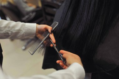 Müşteriyle kuaförde çalışan profesyonel bir kuaför. Uzayı metin için kopyala. Yatay fotoğraf