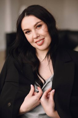 Stüdyoda siyah ceketli ve mavi gecelikli güzel esmer kadın portresi. Gülümseyen kadın. Güzellik ve moda