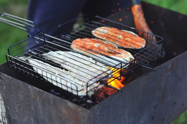 Balık pişiriyorum. Dışarıda ızgarada balık ızgara ediliyor. Barbekü Yemeği. Taze balık ızgarada pişiyor. Açık havada yemek pişirmek