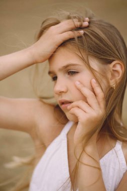 Yazın rüzgârda savrulan saçları olan sevimli küçük bir kızın portresi. Fotoğraf Çekme