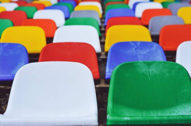 Boş plastik stadyum koltuklarının yakın çekimleri. Çok renkli koltukları olan spor stadyumu