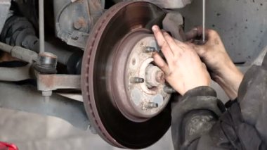 Disk fren pedi ve araba diski fren sistemi değiştirme servisi. Araba diski fren pedi yenileme servisi araba garajındaki tamircinin eliyle. Fren pedlerini yenisiyle değiştirme işlemi. Kirli eller eldiven yok.