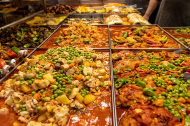 Bir restoranda çok çeşitli sıcak ve sulu Türk yemekleri var. Aşçı yemek servisi yapar. Türk ve Ortadoğu mutfağı