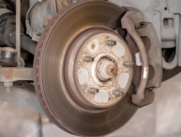 Disk brake pad and car disk brake system change service. Car disk brake pad replacement service by hand of mechanic man in car garage. Process of replacing brake pads with new