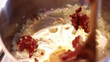 Çelik bir tencerede yağlı, soğanlı ve domatesli pişirme ve kızartma. Ev yapımı, yakın çekim.