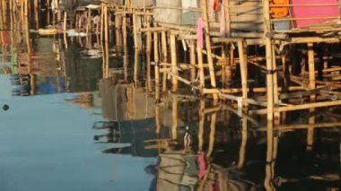 Bambu ayaklıklarındaki kulübelerin deniz suyundaki yansıması