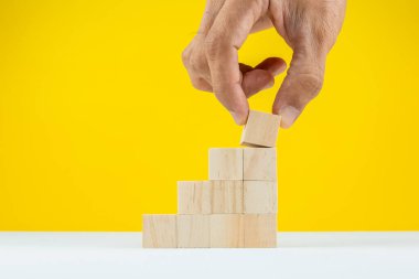 Tahta blokları masaya istifleyen kişinin elleri