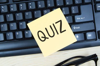 Text Quiz on sticky note on top of keyboard clipart