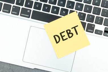 Dizüstü bilgisayardaki sarı yapışkan notlar üzerindeki borç metni.