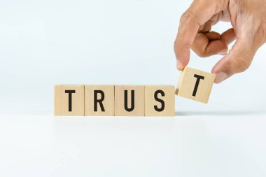 Tahta blokta beyaz arkaplanlı 'güven' metni.