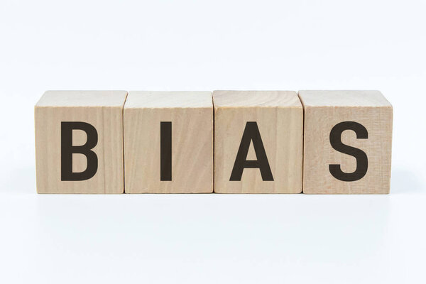 Предвзятое слово на деревянном блоке с белым фоном.