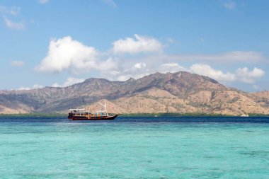 Taka Makasar Adası, Flores Adası, Endonesi 'deki sahil ve turistik tekne manzarası.