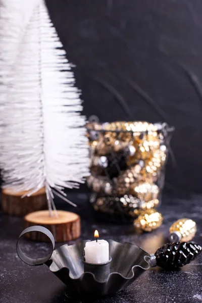 年賀状 黒の質感の背景に対する小さなキャンドル バスケットと白の木の装飾コーンを燃焼とヴィンテージキャンドルホルダー 北欧ミニマルなスタイル 静物画 — ストック写真